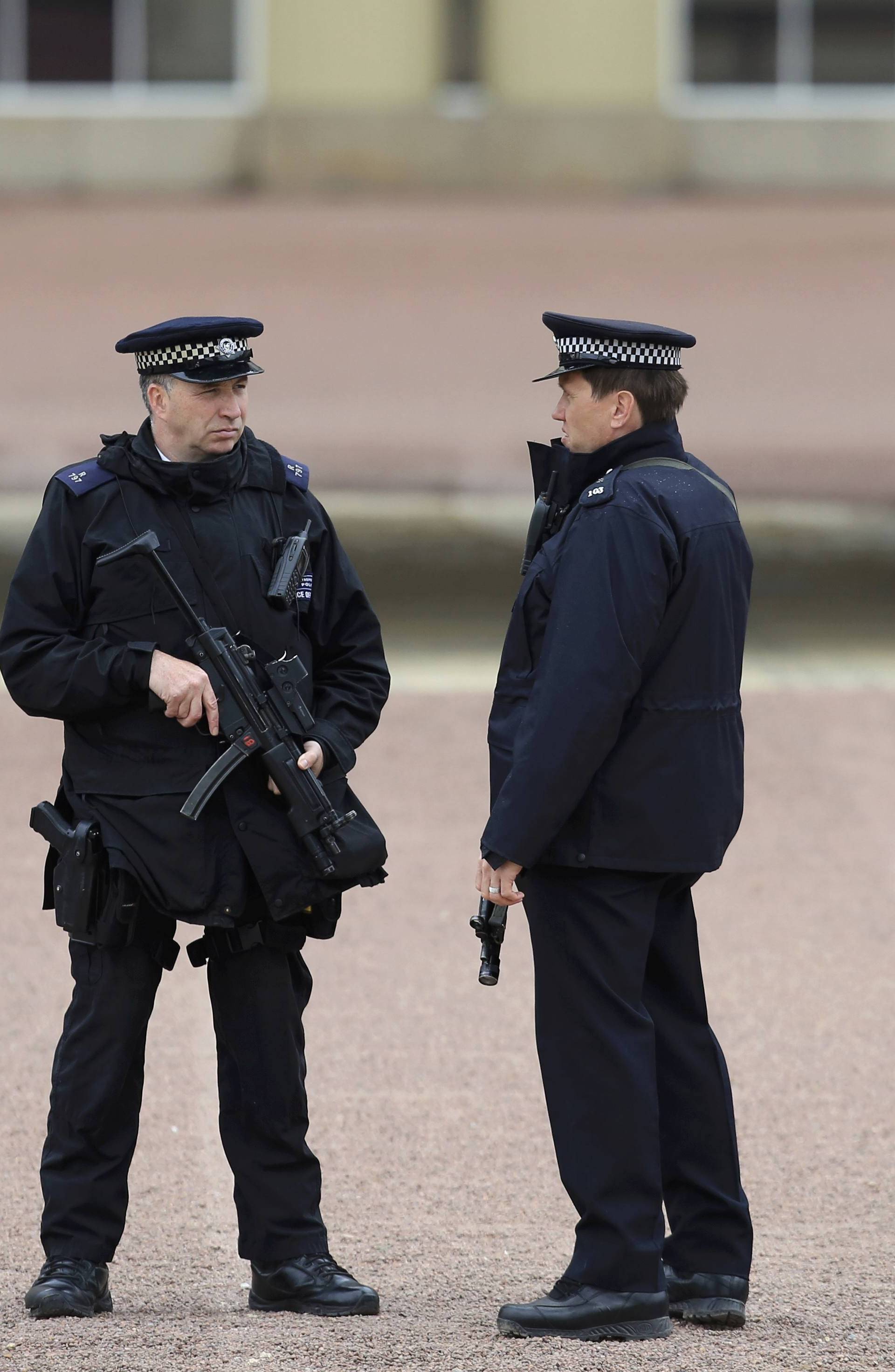 Armed police officers stand on duty at Buckingham Palace in London