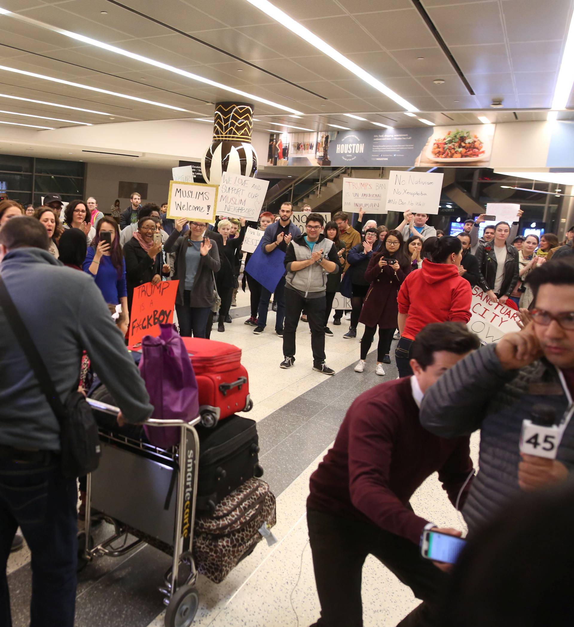 A Palestinian family is greeted by protesters after the father was detained for hours at George Bush Intercontinental Airport in Houston