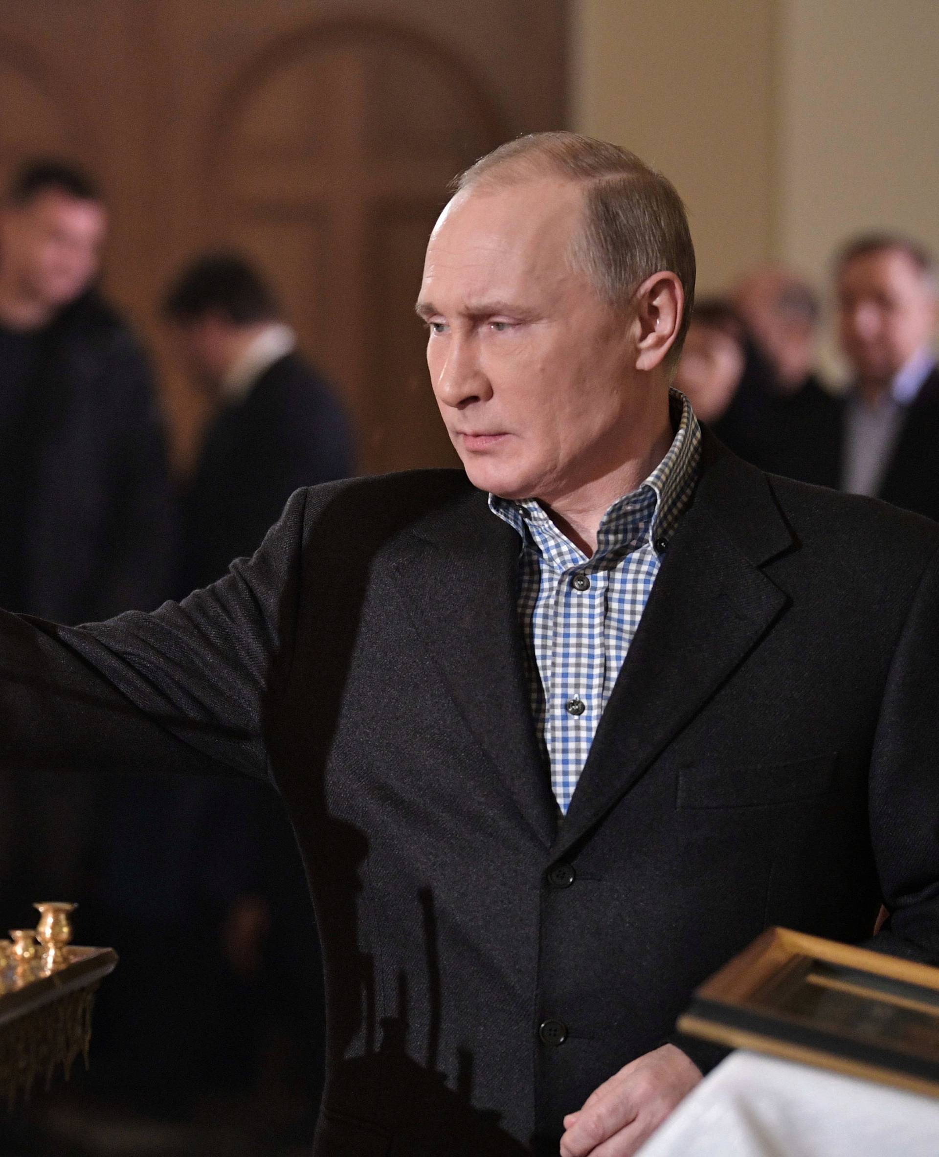 Russian President Vladimir Putin attends a service on Orthodox Christmas at the Church of Saints Simeon and Anna in St. Petersburg