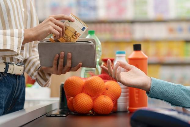 Woman,Paying,For,Her,Groceries,At,The,Supermarket,Checkout,,She