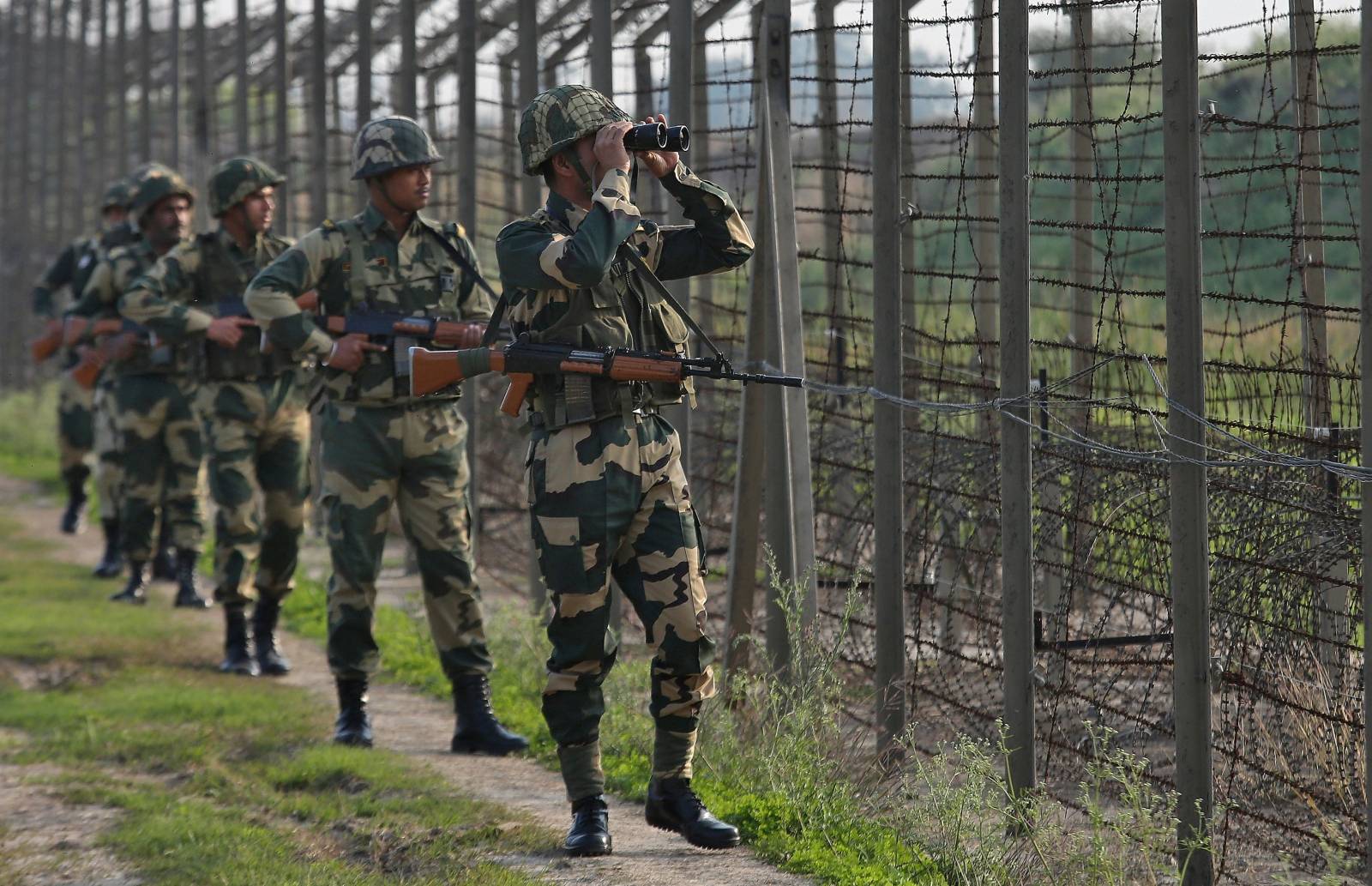 India's Border Security Force soldiers patrol along the fenced border with Pakistan in Ranbir Singh Pura sector