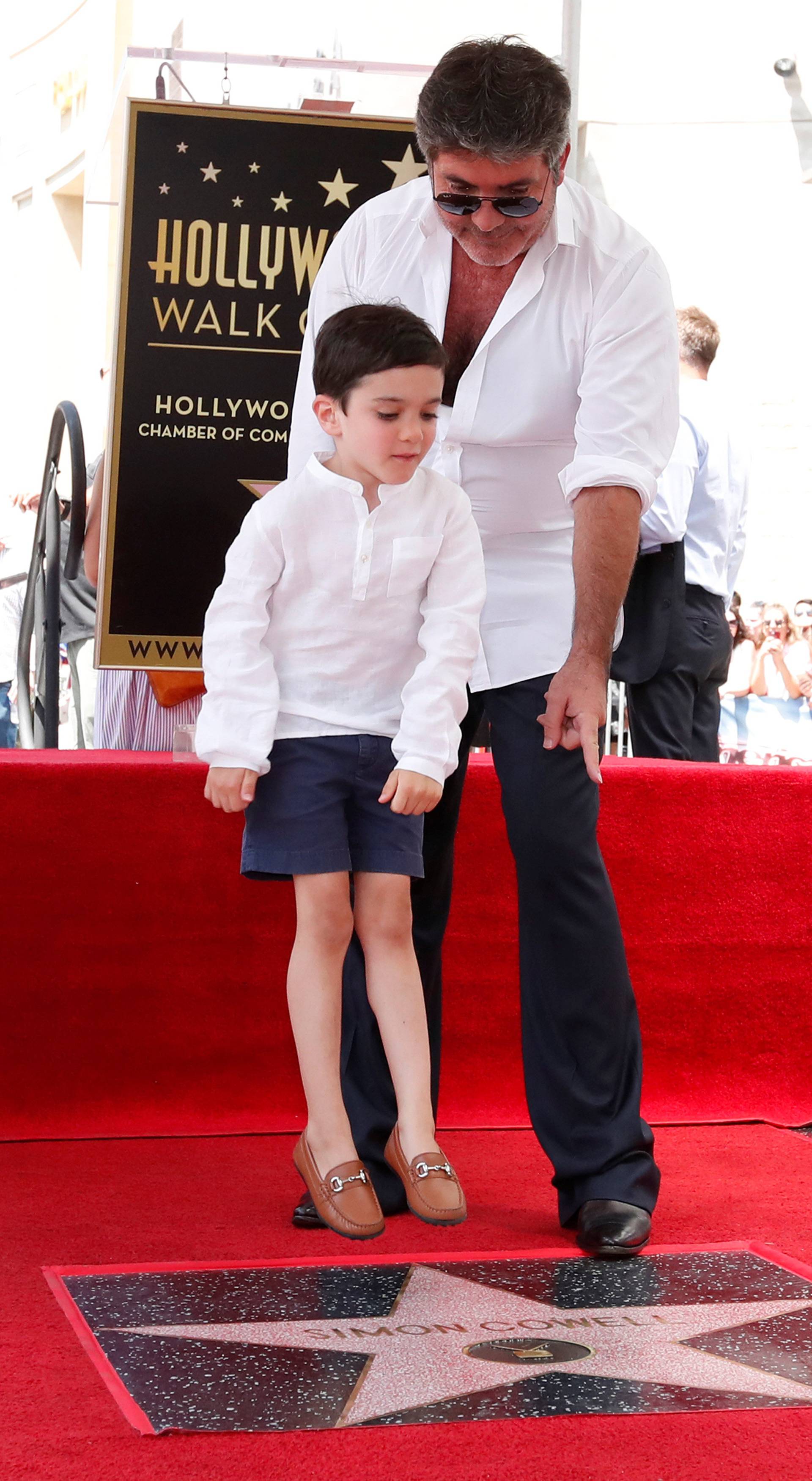 Television producer Cowell and his son Eric pose on his star on the Hollywood Walk of Fame in Los Angeles