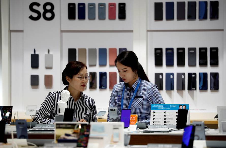 An employee helps a customer purchase a Samsung Electronics' Galaxy Note 8 at its store in Seoul