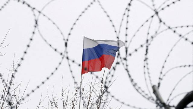 FILE PHOTO: The Russian flag is seen through barbed wire as it flies on the roof of the Russian embassy in Kiev