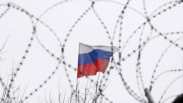 FILE PHOTO: The Russian flag is seen through barbed wire as it flies on the roof of the Russian embassy in Kiev