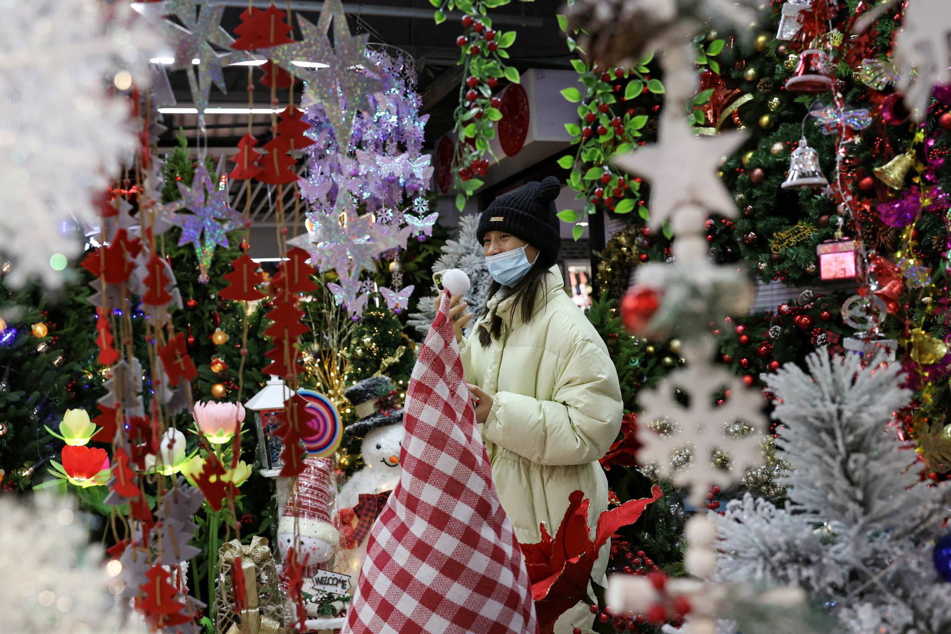 Customer shops at a booth selling Christmas decorations at a mall in Beijing