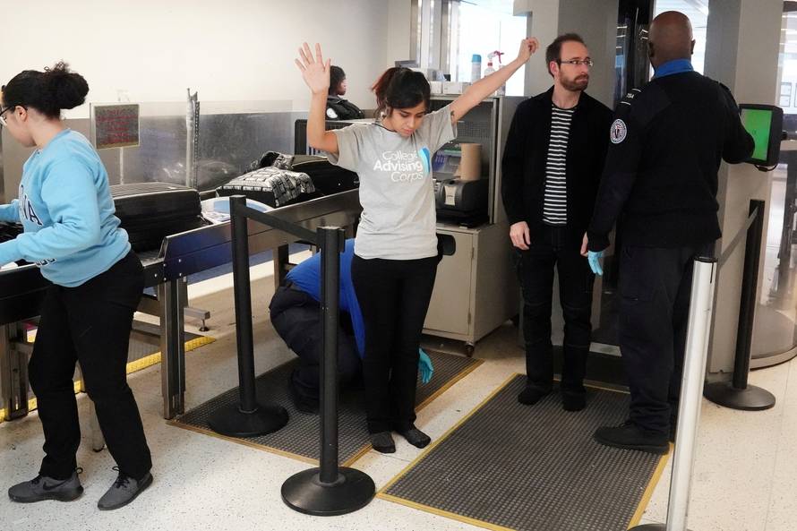 FILE PHOTO: TSA agents check passengers at a security checkpoint at LaGuardia Airport in the Queens borough of New York City