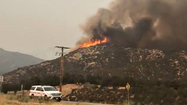 A still image from video obtained from social media of a fire burning vegatation on a hill in Yucaipa