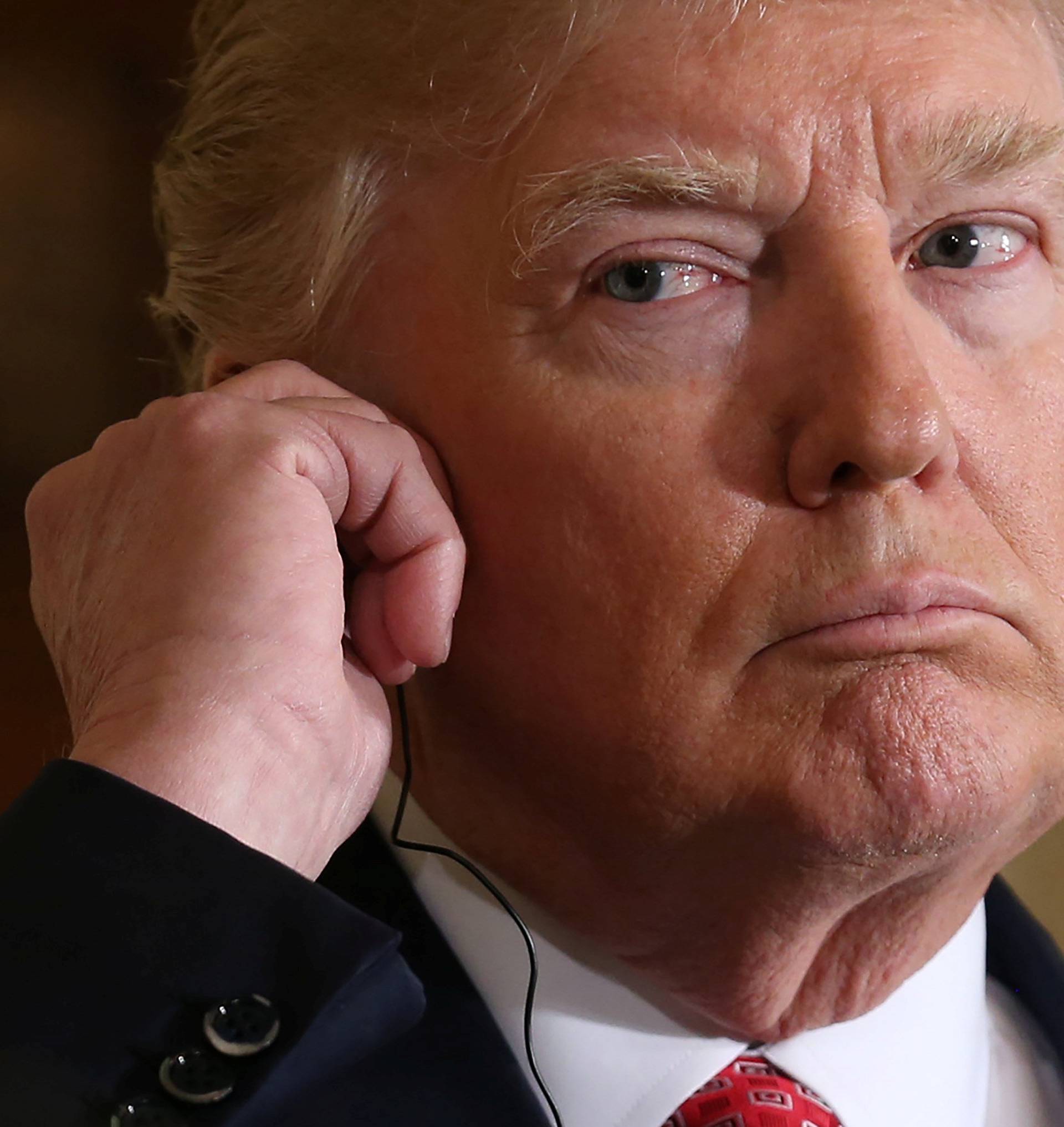 U.S. President Donald Trump listens to a translation during a joint news conference with Japanese Prime Minister Shinzo Abe at the White House in Washington