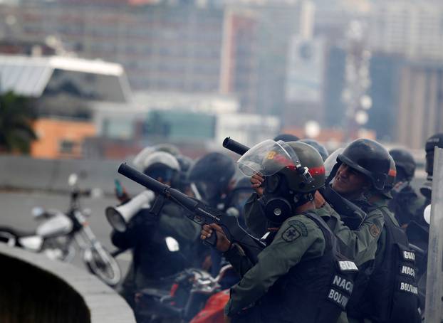 Riot police take position while clashing with demonstrators during the so-called "mother of all marches" against Venezuela