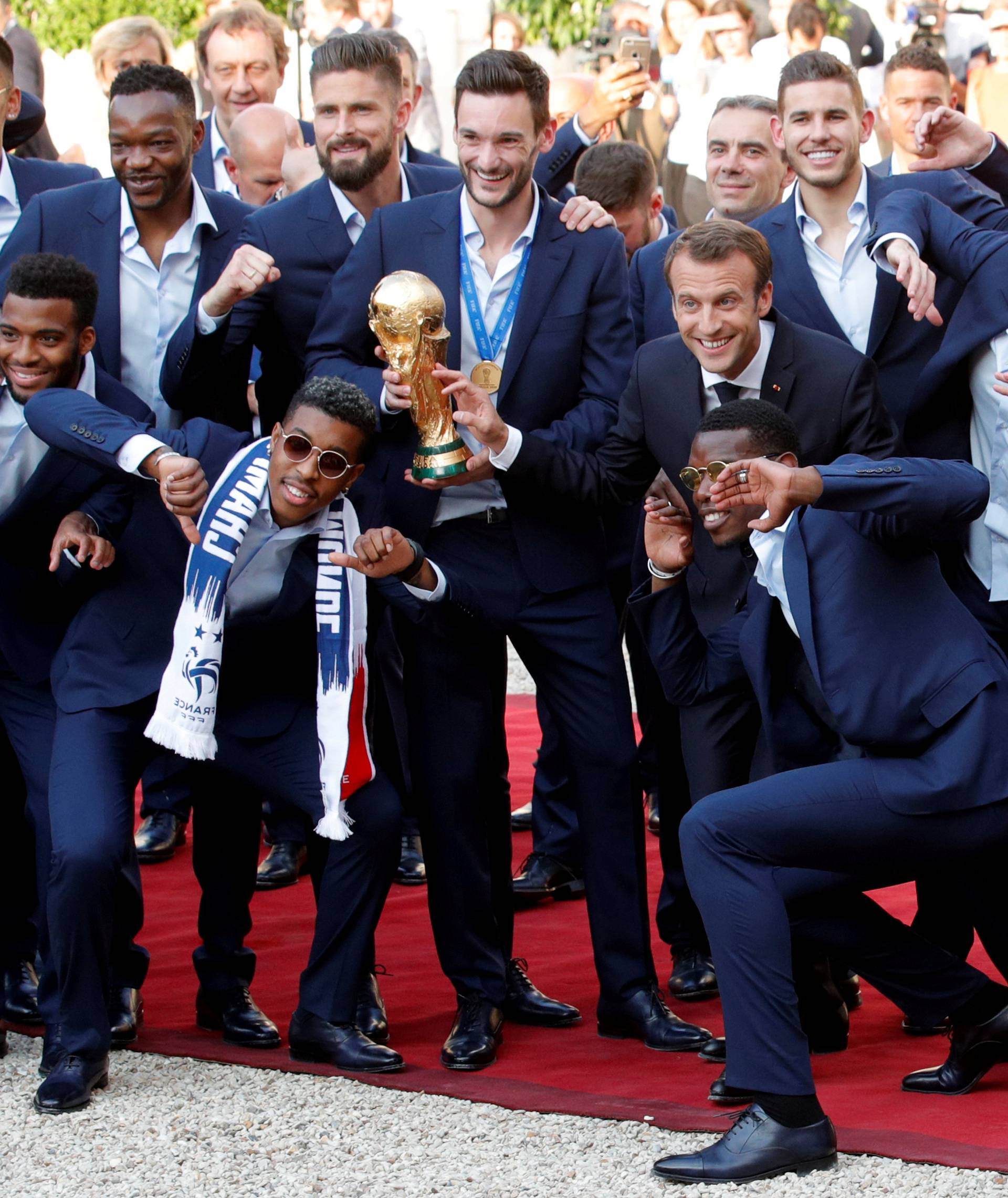 French President Emmanuel Macron and his wife Brigitte Macron pose with France soccer team captain Hugo Lloris holding the trophy, coach Didier Deschamps and players before a reception to honour the France soccer team at the Elysee Palace in Paris