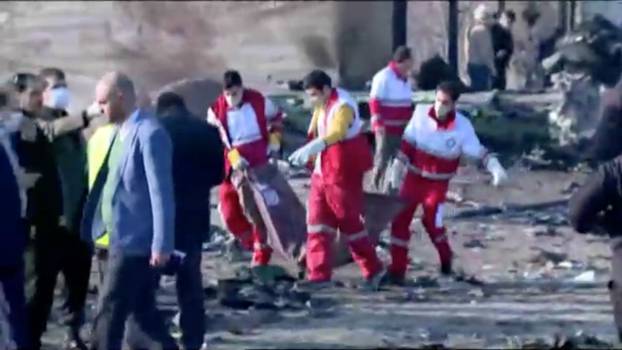 Emergency workers work near the wreckage of Ukraine International Airlines flight PS752, a Boeing 737-800 plane that crashed after taking off from Tehran