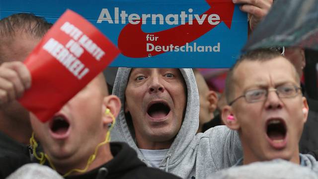 Supporters of the hard-right Alternative for Germany (AfD) party shout slogans durig an election campaign rally of German Chancellor Angela Merkel in Torgau