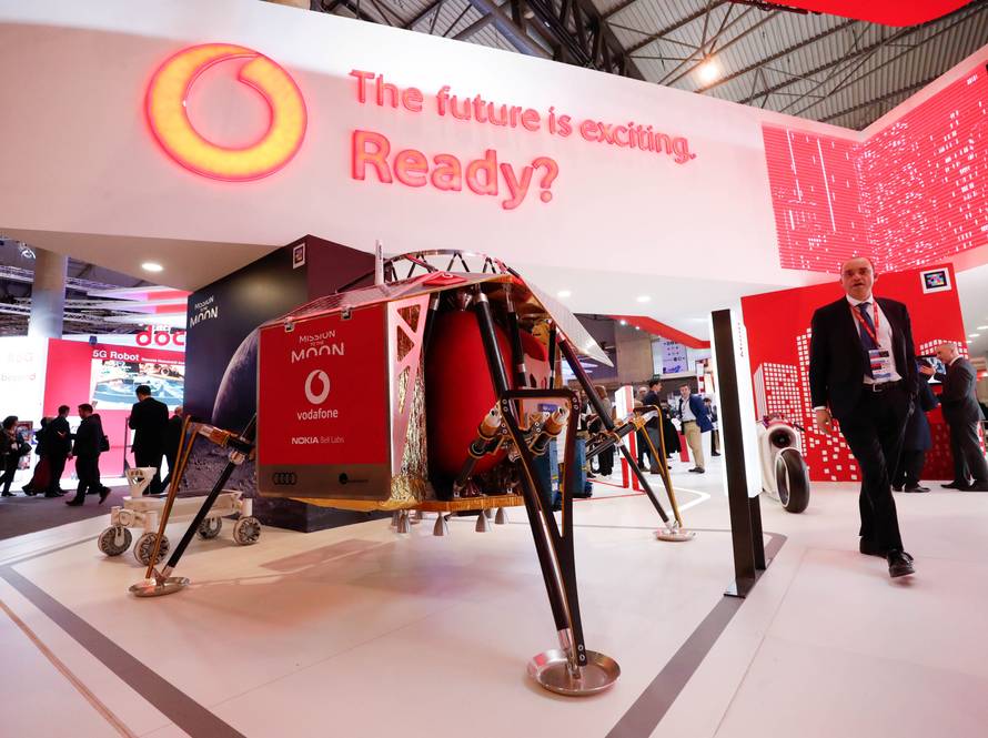 A visitor walks past a mobile mast with an Audi lunar exploration vehicle during the Mobile World Congress in Barcelona