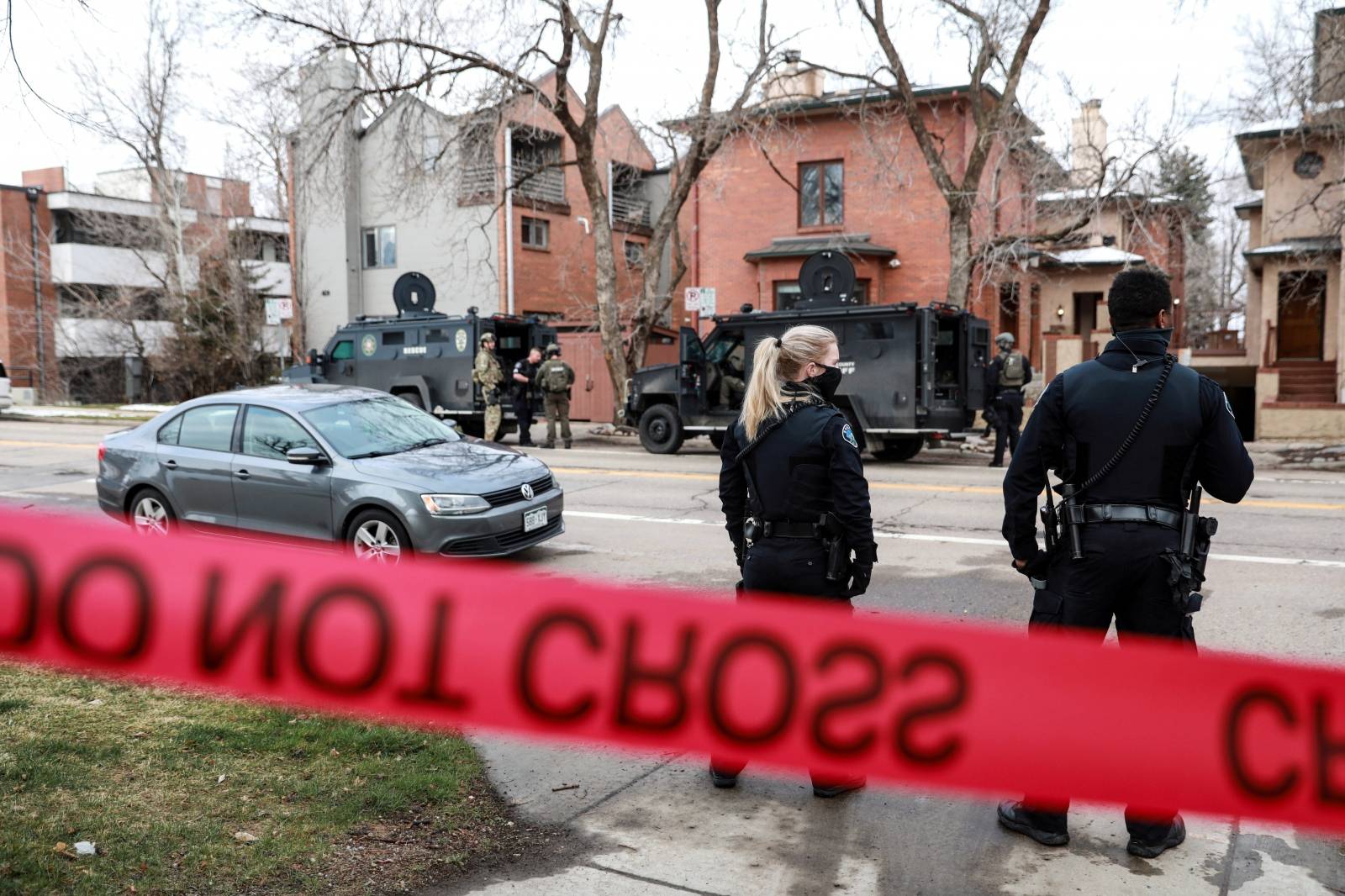 Law enforcement officers stand at the perimeter of a home in Boulder as part of their investigation into a shooting at King Soopers grocery store, before leaving after finding no connection to the incident, in Boulder