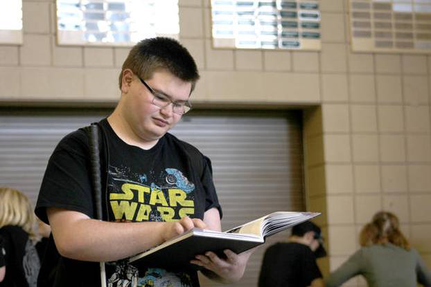 RJ Sampson reads his yearbook in the entryway of Conifer High Sc