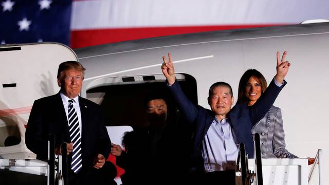 One of the Americans formerly held hostage in North Korea gestures next to U.S.President Donald Trump and first lady Melania Trump, upon their arrival at Joint Base Andrews