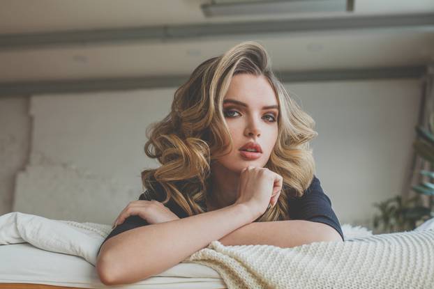 Pretty young woman resting on the bed at home