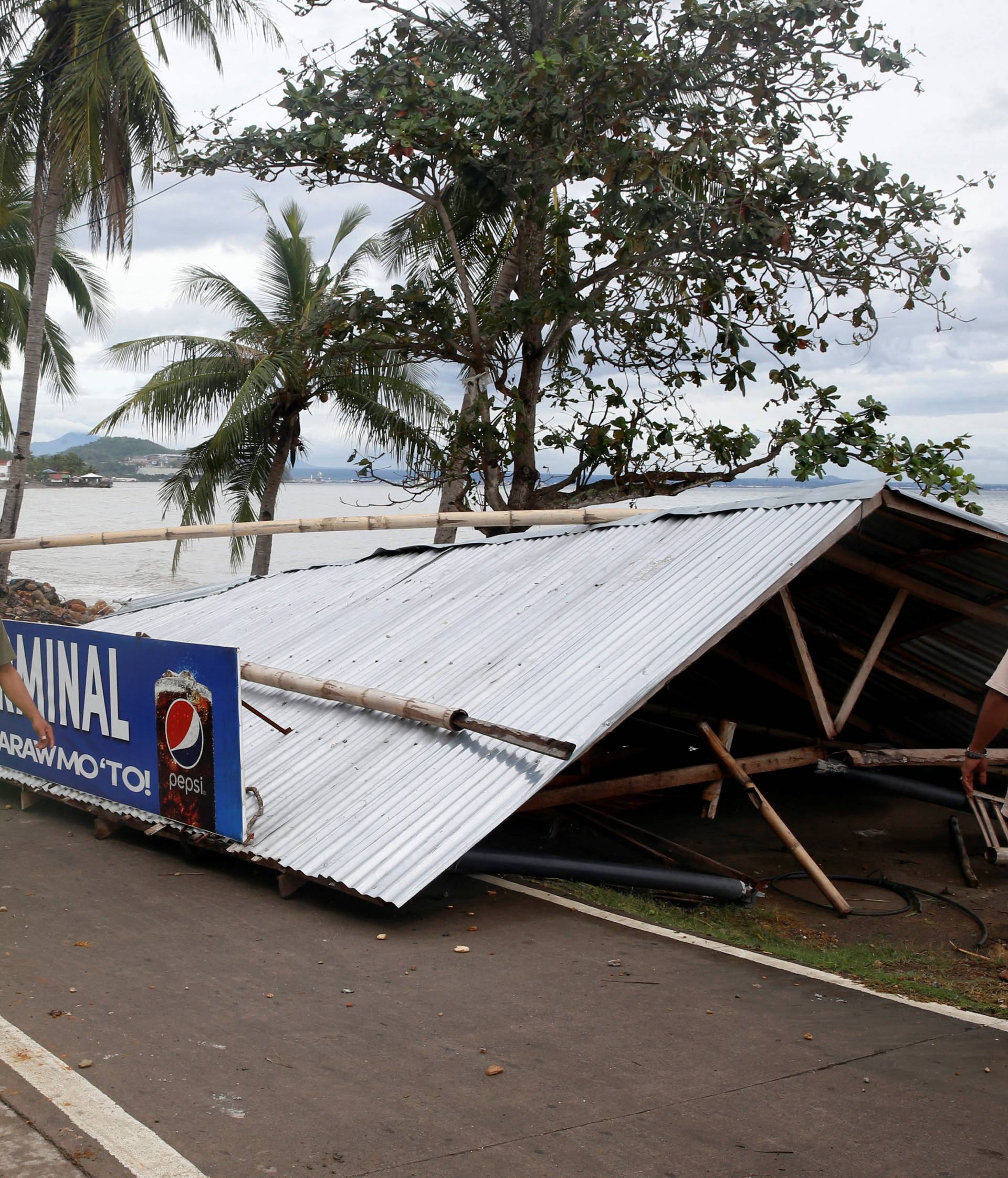 A passenger waiting shed is pictured after it was toppled by strong winds at the height of Typhoon Nock-Ten in Mabini, Batangas