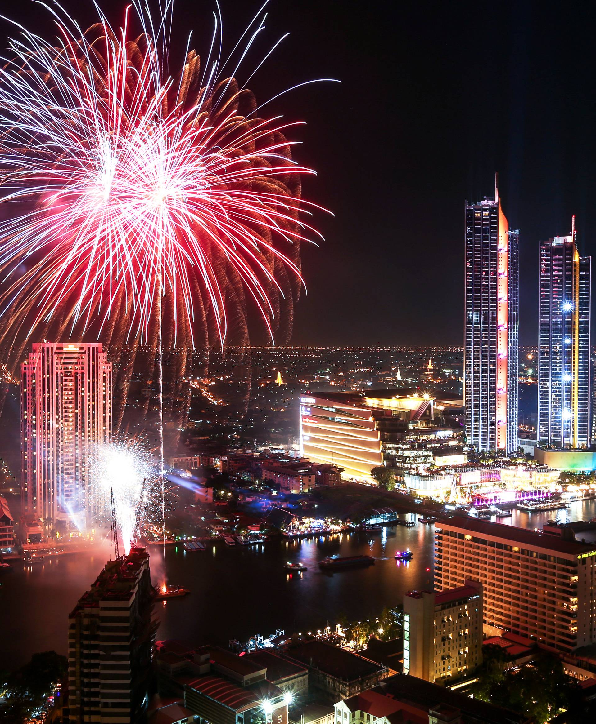 Fireworks explode over Chao Phraya River during the New Year celebrations in Bangkok