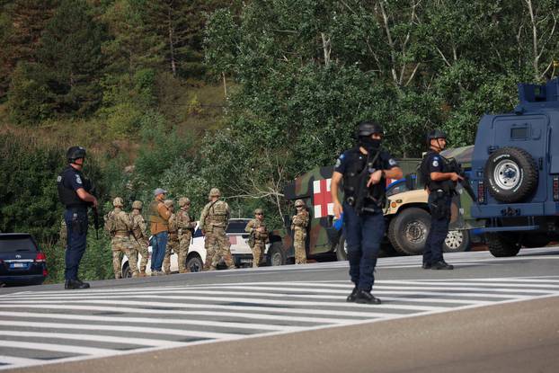 Kosovo police and U.S. and EU troops stand by after one police officer was killed, another hurt in Kosovo gunfire, in Josevik