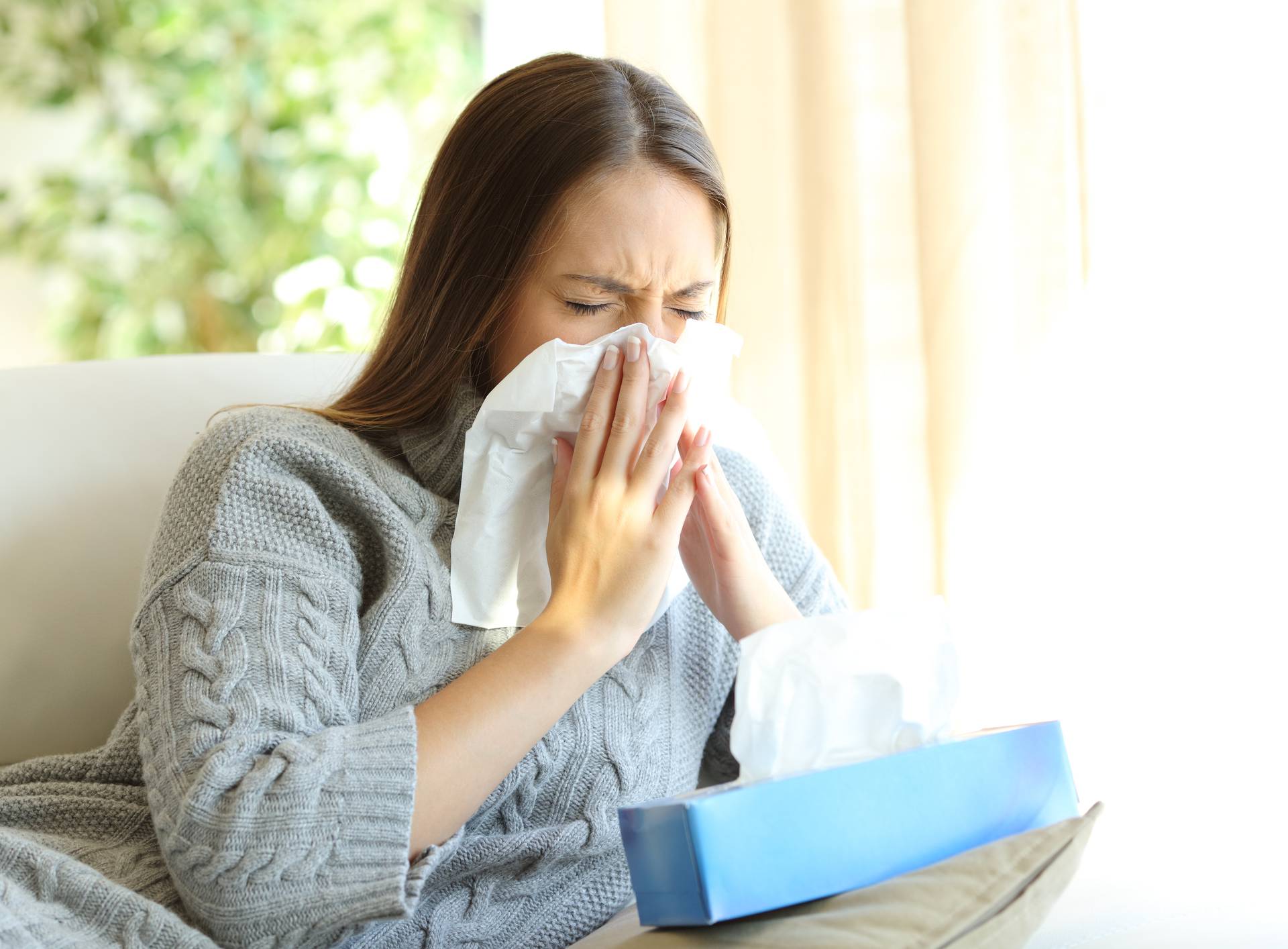 Woman blowing with flu in winter
