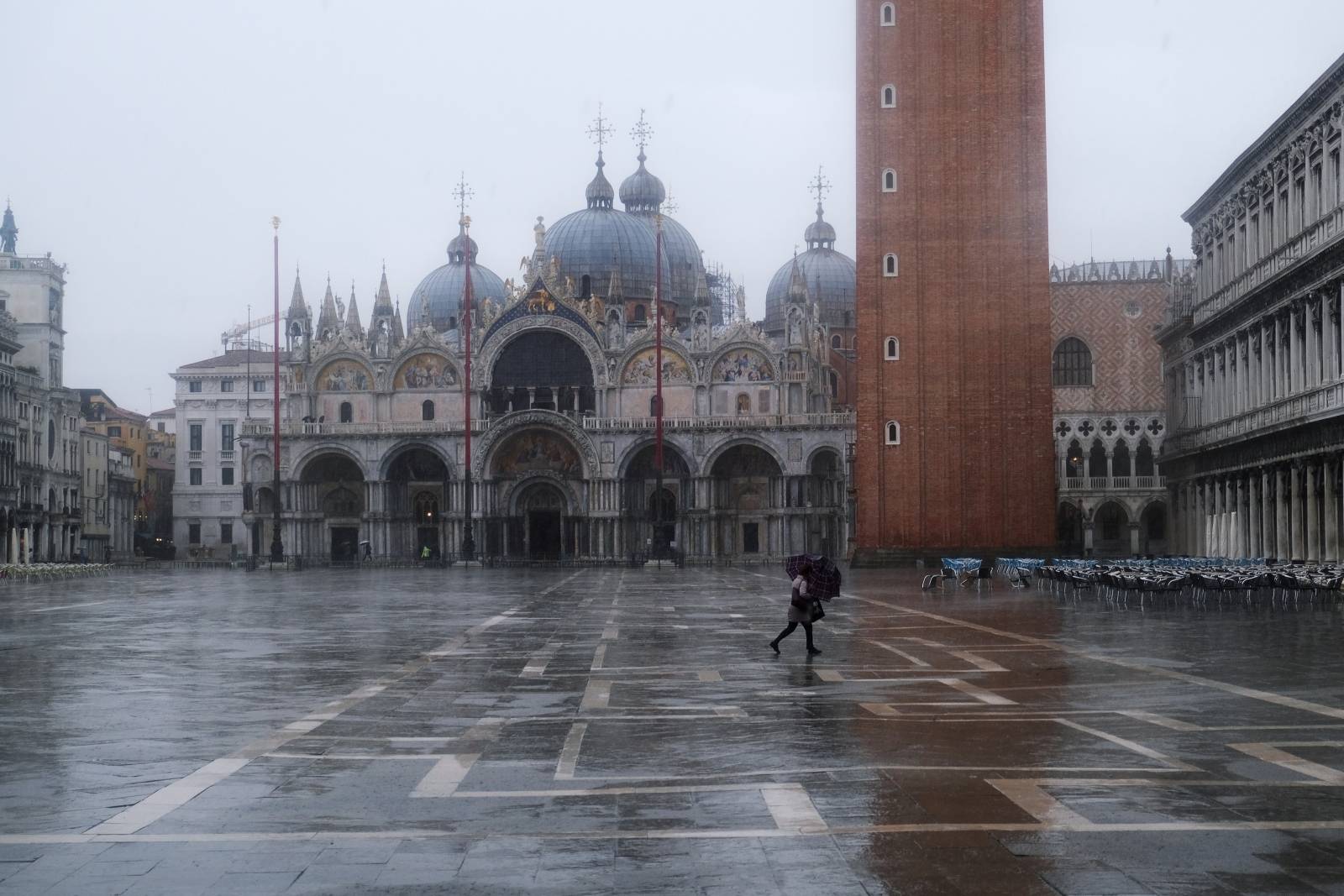 A woman walks in St. Mark's Square during high tide as the flood barriers known as Mose are raised for the second time, successfully protecting the lagoon city from flooding, in Venice
