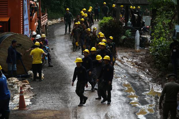 Military personnel walk in line as they prepare to enter the Tham Luang cave complex, where 12 boys and their soccer coach are trapped, in the northern province of Chiang Rai