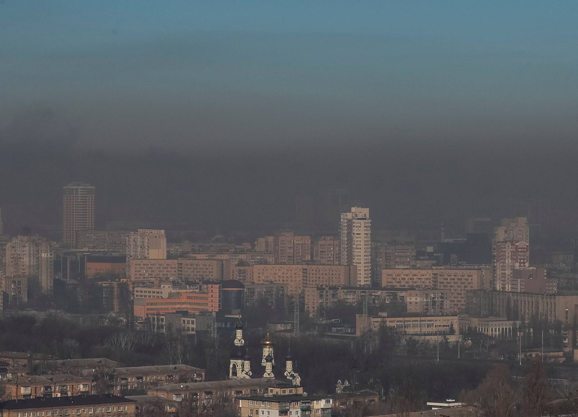 Residential buildings in Kyiv are seen through smoke from fires after shelling nearby