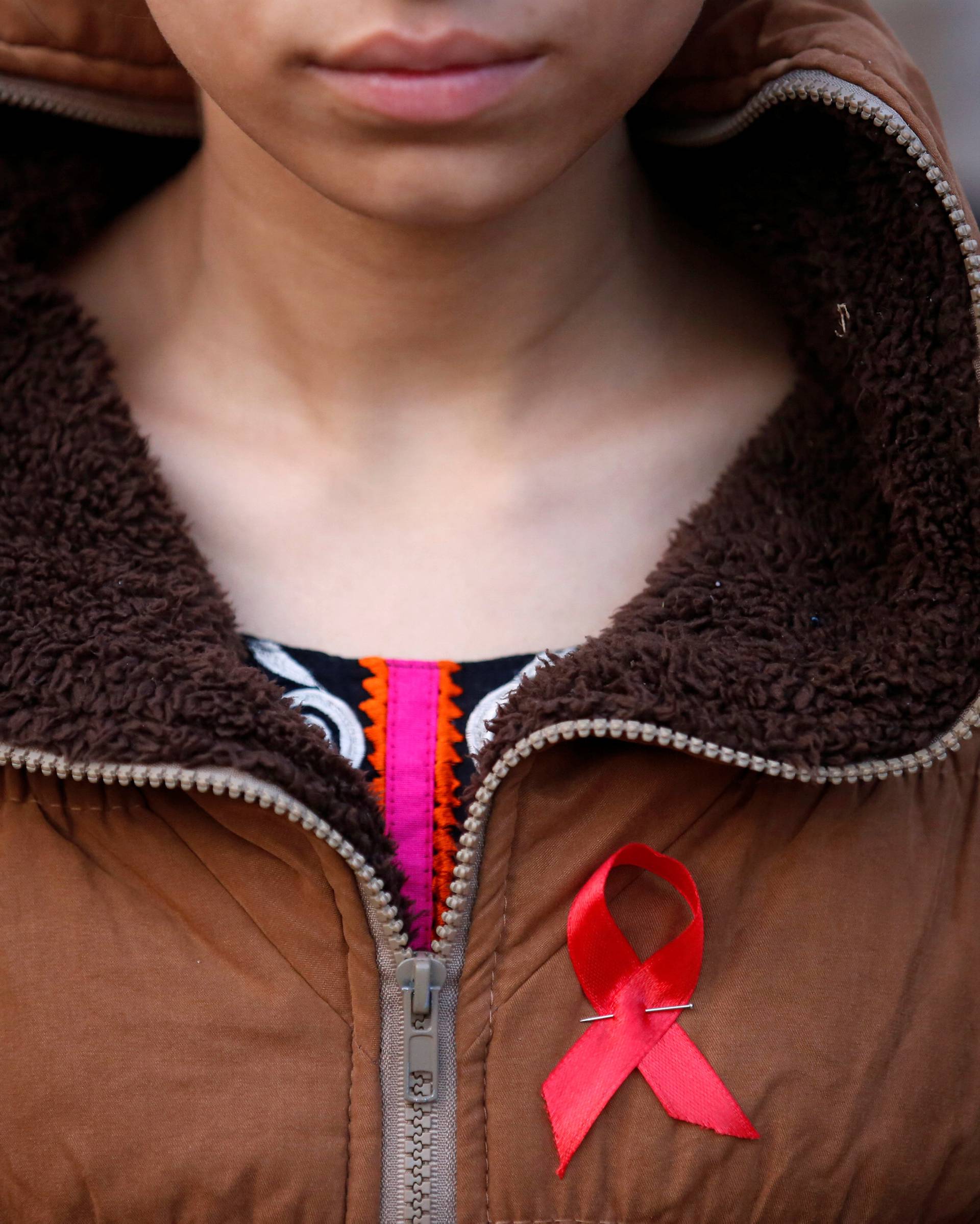A participant with a red ribbon pin takes part in HIV/AIDS awareness campaign ahead of World Aids Day, in Kathmandu