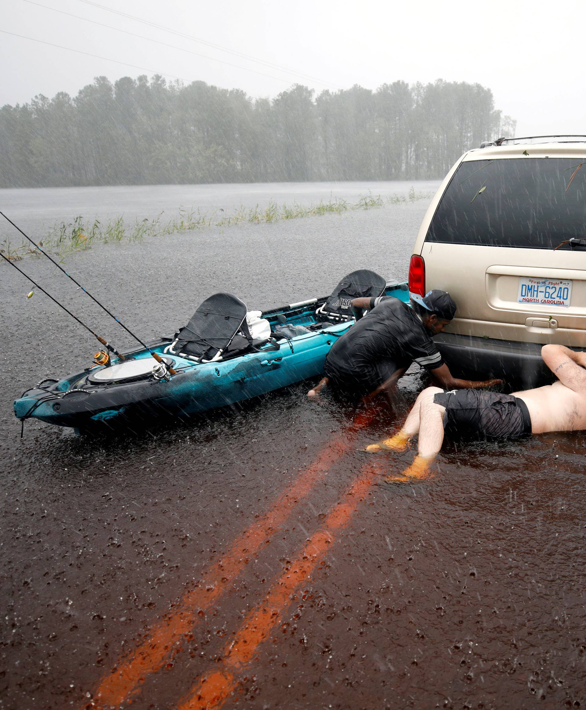 Jordan McKeon and Nathaniel Harrison try to free stalled car after Hurricane Florence struck in Boiling Spring Lakes
