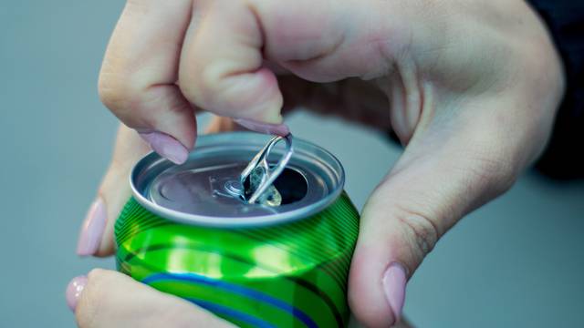 Close up of a hand opening a beverage