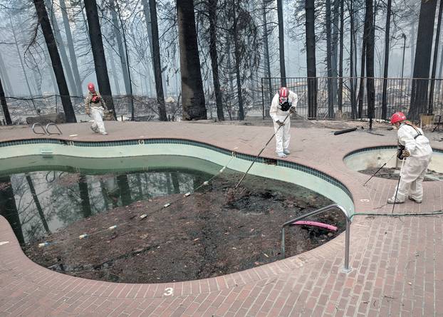 Forensic investigators search a community swimming pool for victims of the Camp Fire in Paradise