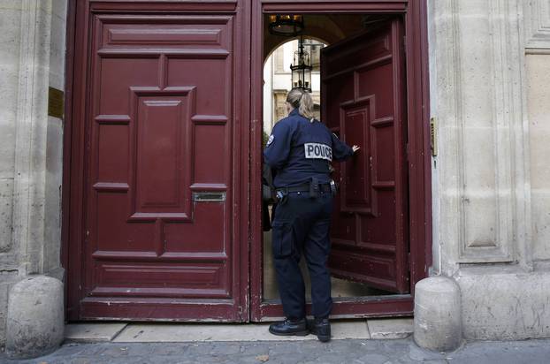 A police officer stands guard at the entrance of a luxury residence on the Rue Tronchet in Paris