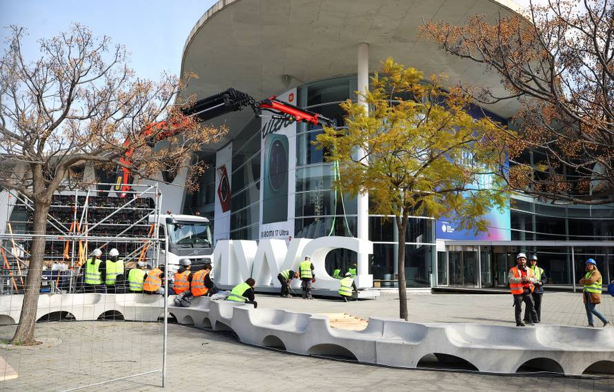Workers place a giant MWC logo ahead of the Mobile World Congress (MWC)