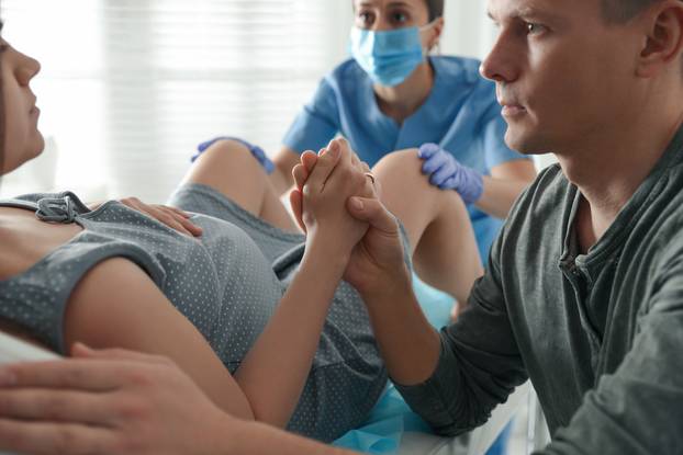 Woman giving child birth in maternity hospital, closeup