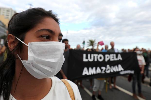 A woman with a mask attends a demonstration to demand more protection for the Amazon rainforest in Rio de Janeiro