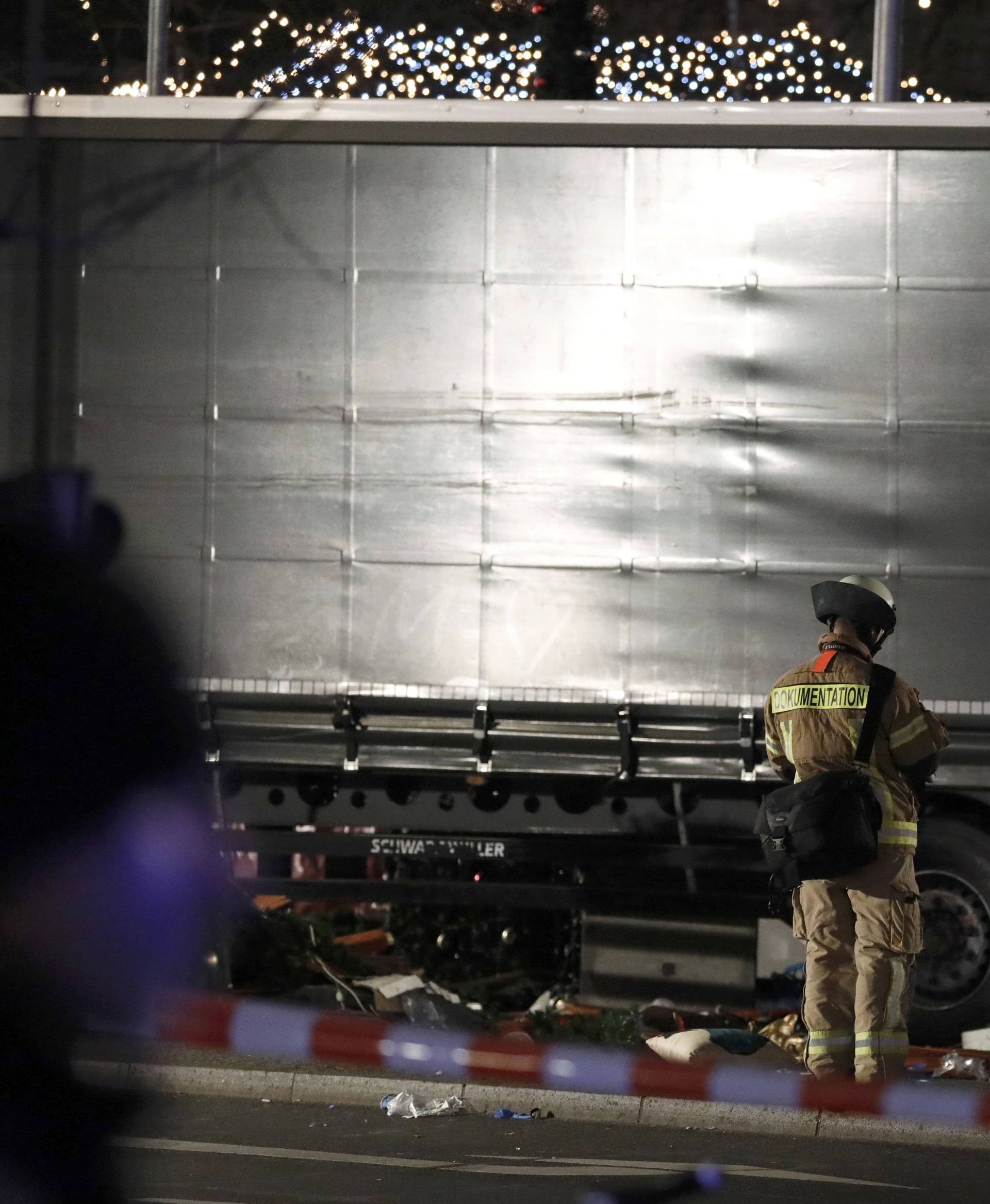 An official stands beside a truck at a Christmas market in Berlin