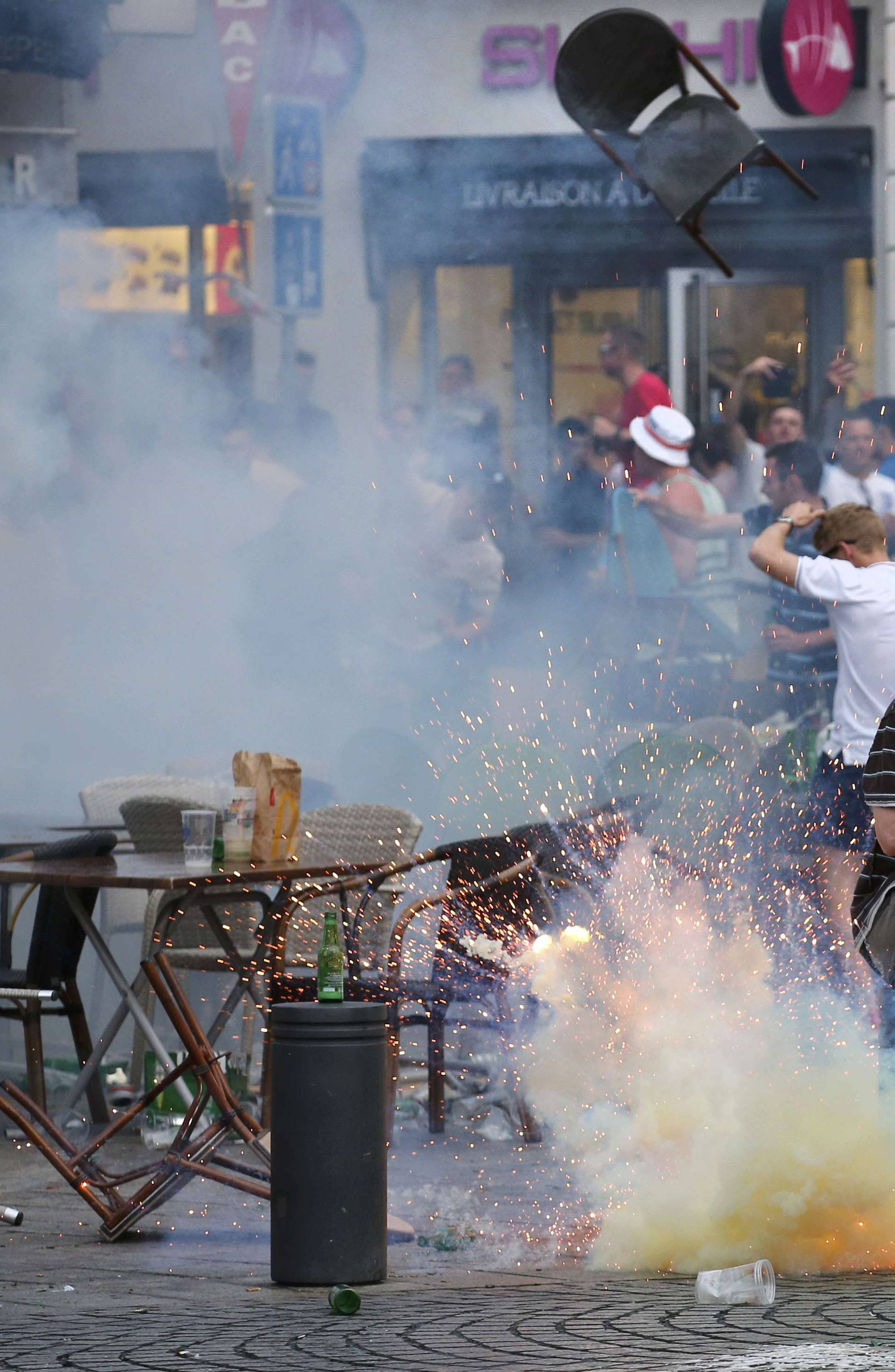 A teargas grenade explodes near an England fan ahead of England's EURO 2016 match in Marseille