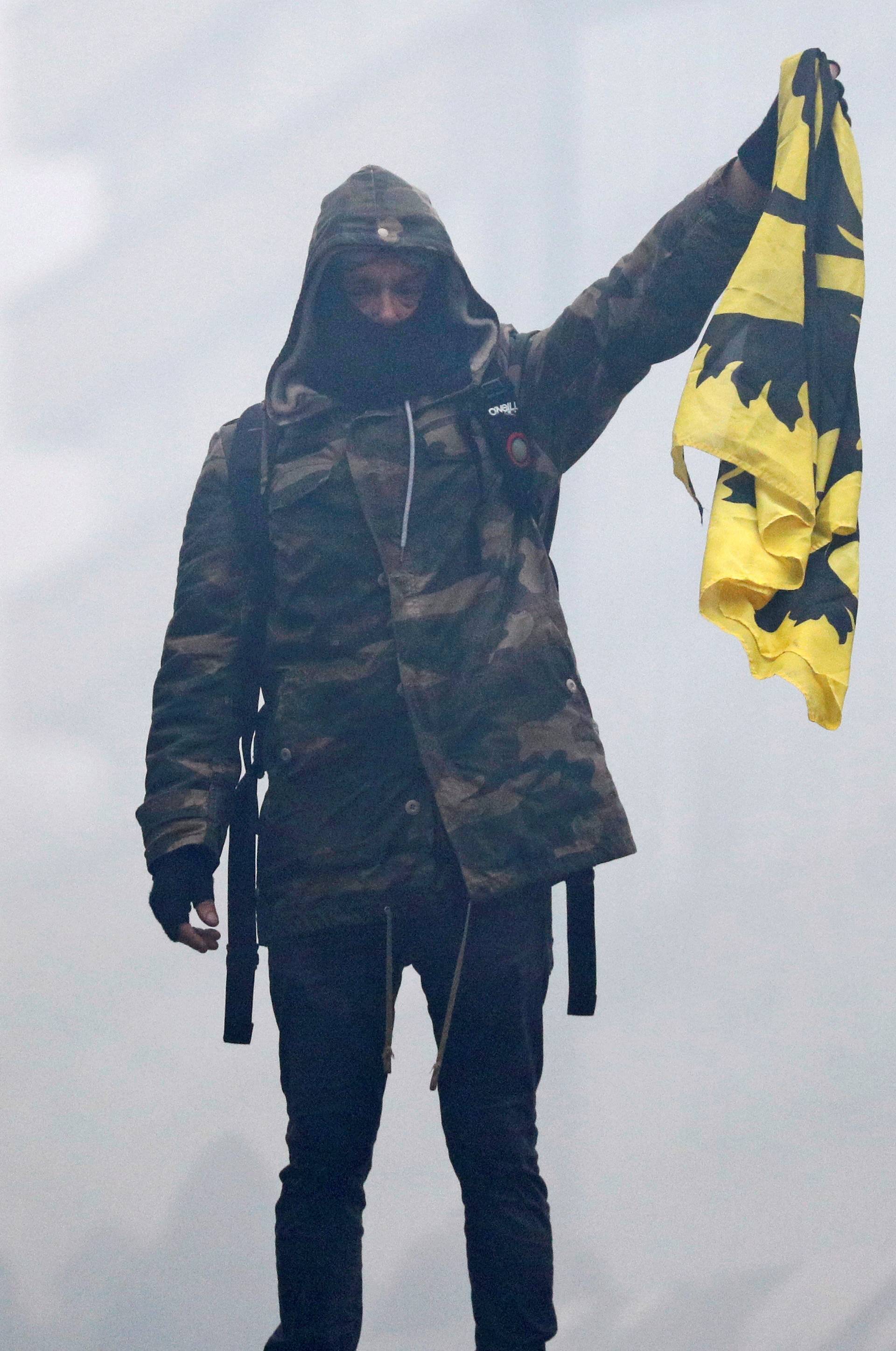 Flemish nationalist holds a Flemish flag as he attends a protest against Marrakesh Migration Pact in Brussels