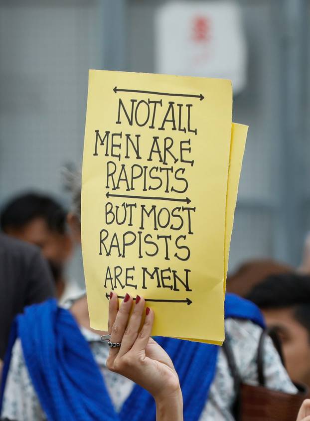 FILE PHOTO: A woman carries a sign against a gang rape that occurred along a highway and to condemn violence against women and girls, during a protest in Karach