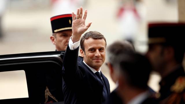 French President-elect Emmanuel Macron waves as he arrives to attend a handover ceremony with outgoing President Francois Hollande at the Elysee Palace in Paris