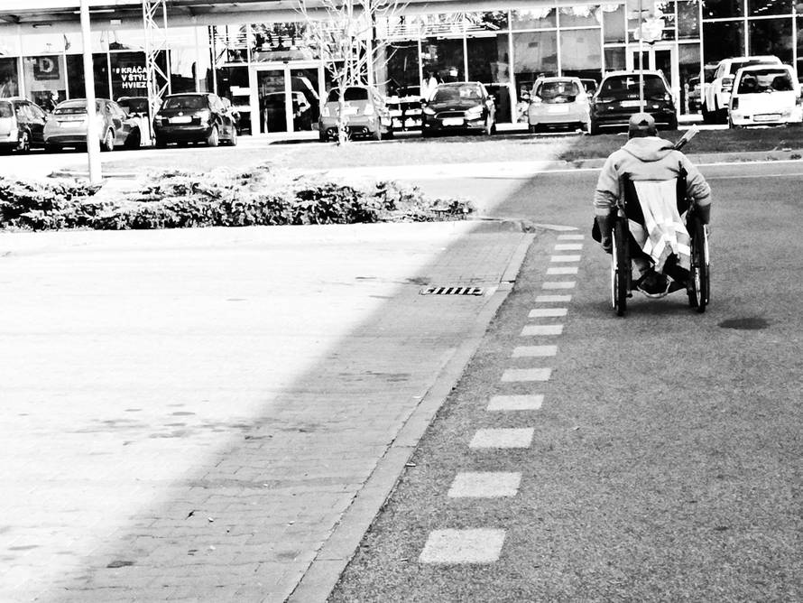 A man using wheel chair on an empty road in Stuttgart - Germany. Black and white image