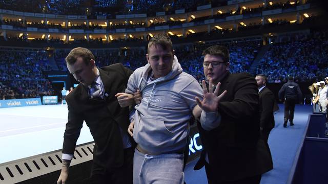 Security apprehend a spectator that attempted to invade the court during the semi final match between Japan's Kei Nishikori and Serbia's Novak Djokovic