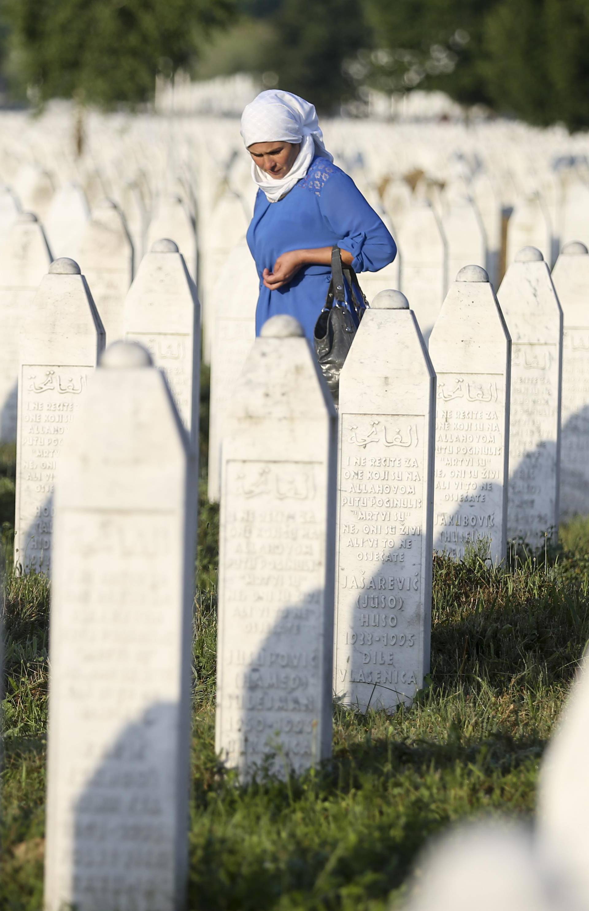 A woman walks among graves in Memorial Center Potocari, near Srebrenica