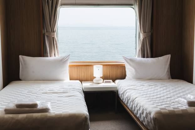 Bedroom with interior of double passenger cabin ferry ship with ocean view.