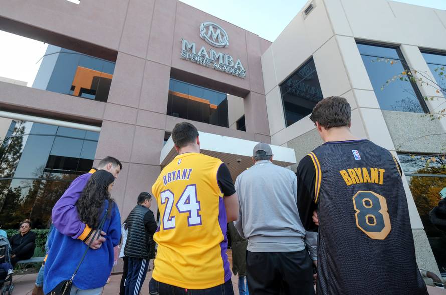 Fans gather at a makeshift memorial for former NBA player Kobe Bryant outside of the Mamba Sports Academy in Thousand Oaks