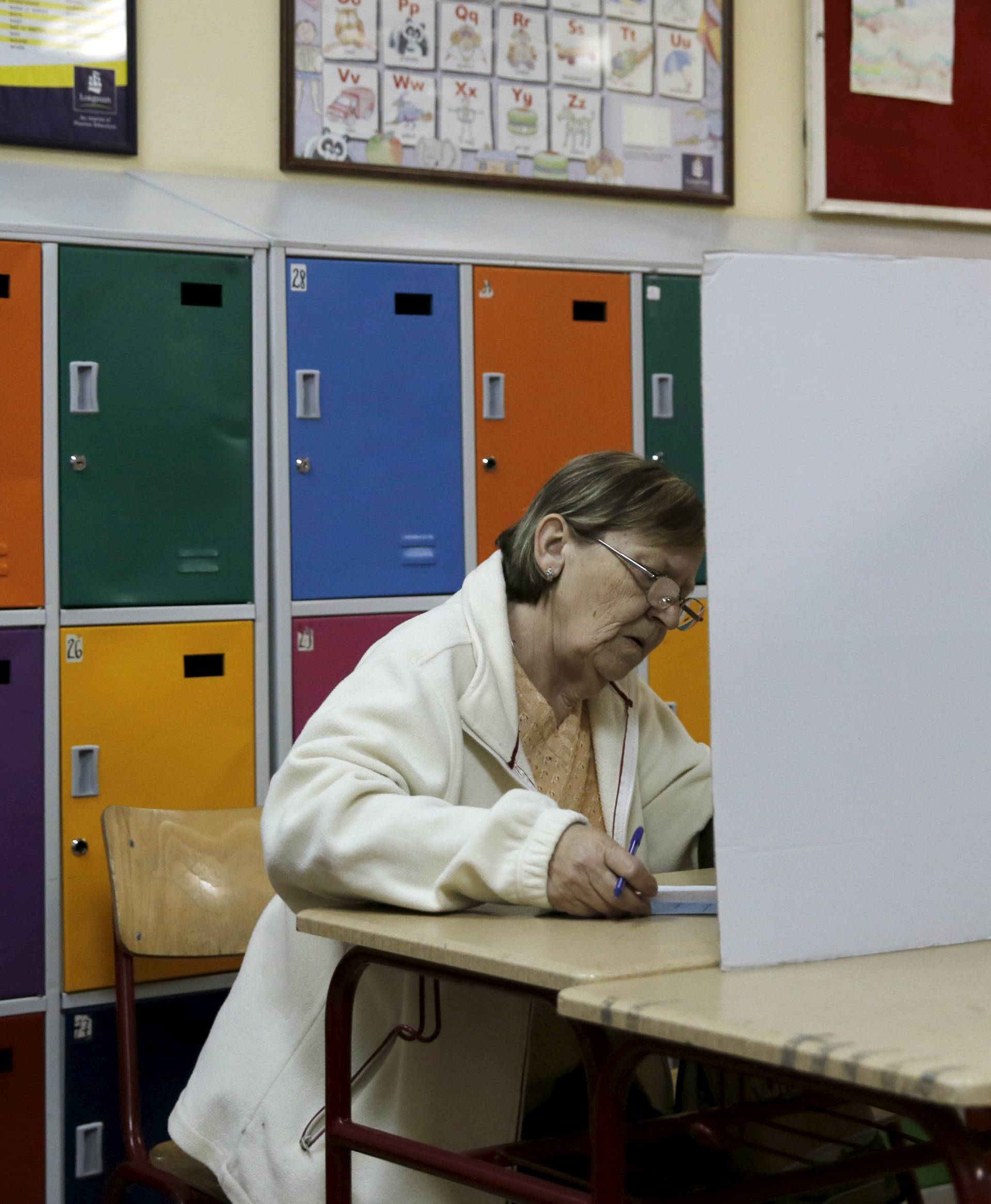 A woman casts her vote at a polling station during elections in Belgrade