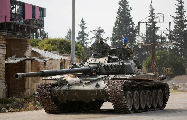 FILE PHOTO: Rebels led by the Islamist militant group Hayat Tahrir al-Sham drive a military vehicle in al-Rashideen