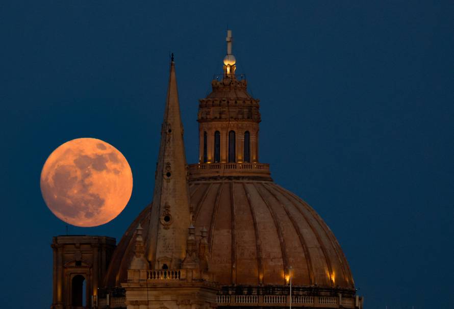 A full moon known as the Strawberry Moon rises behind St Paul's Anglican Cathedral and the Basilica of Our Lady of Mount Carmel in Valletta